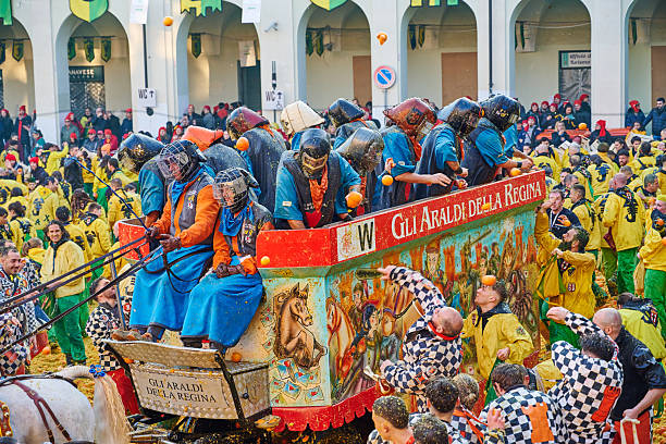 Ivrea, Italy - March 02, 2025: groups in traditional dressing take part in the Battle of the Oranges, where a teams of orange handlers on foot throw oranges (representing old weapons and stones) against aranceri of the team \