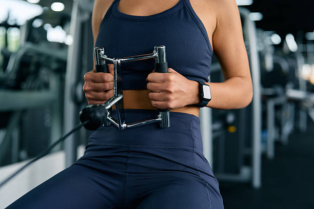 istock Woman exercising back muscles using cable row machine in gym 2215109543