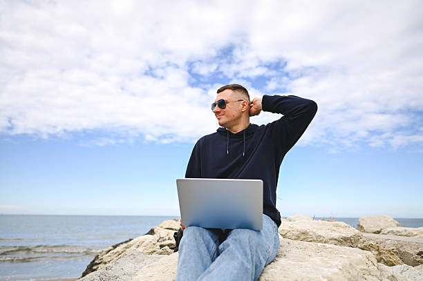 istock Freelancer working on laptop by the sea enjoying the breeze 2215109802