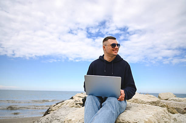istock Freelancer working on laptop by the sea enjoying nature 2215109818