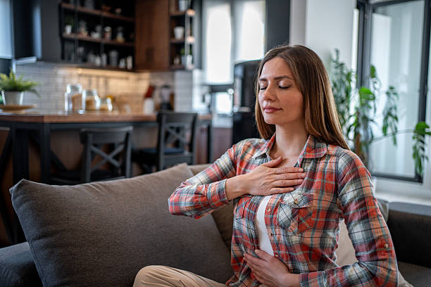 istock Serene woman practicing deep breathing exercise at home 2215111206