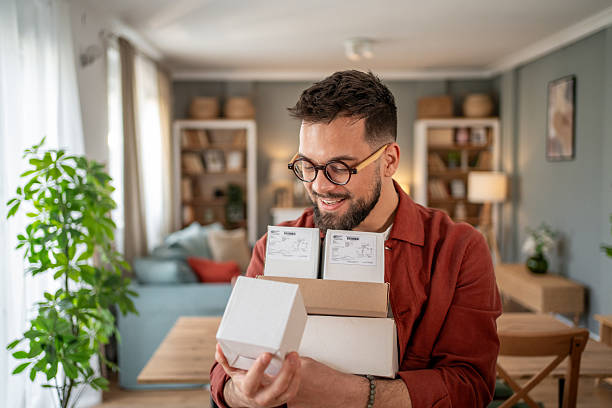 istock Happy man holding parcels at home: receiving online orders 2215114950