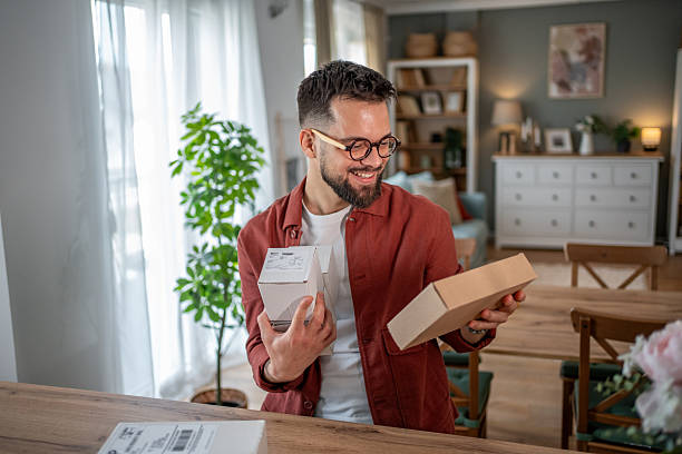 istock Happy man unpacking cardboard boxes at home 2215115173
