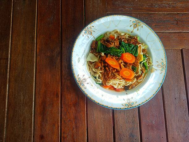 Korean noodles with vegetables in a glass bowl. A portion of noodles.