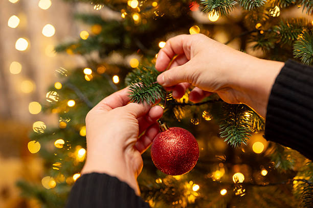istock Woman hanging ornament on Christmas tree 2215117255