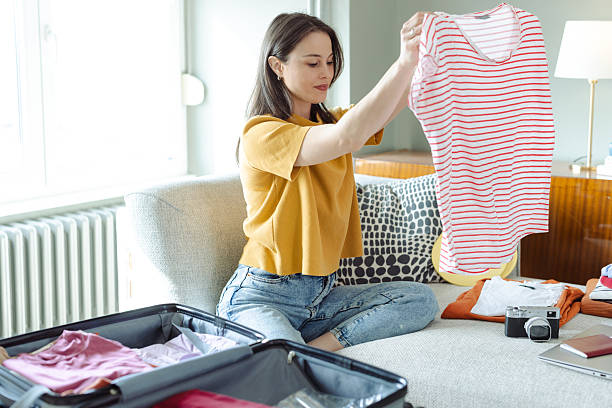 istock Young woman packing a suitcase in her modern home interior 2215119433