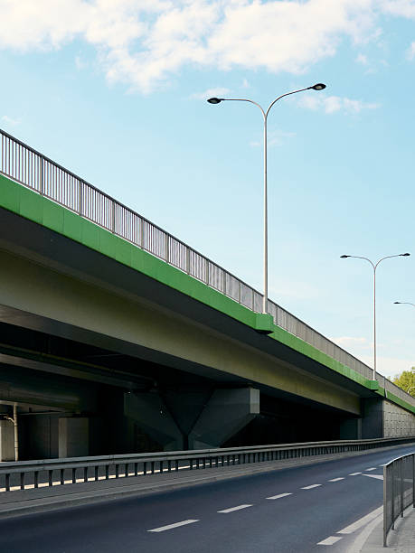 istock Bridge with a green railing and a street with a white line 2215120642