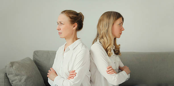 Upset offended caucasian two women, mature mother or sister and adult daughter together at home stock photo