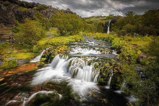 istock Breathtaking Waterfall Amidst Lush Greenery and Clouds 2215128053