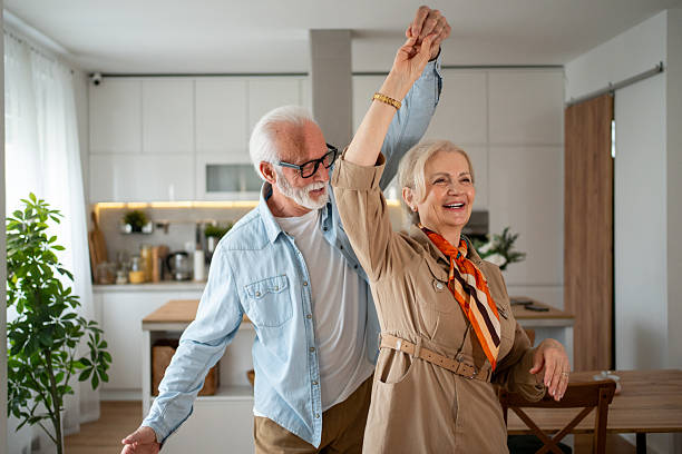 istock Happy senior couple dancing together in their modern kitchen 2215128515