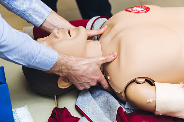 istock First aid training course with dummy, CPR emergency reanimation procedure on mannequin, instructor demonstrating medical training with doll, chest compression and applying bandage and tourniquet 2215129341