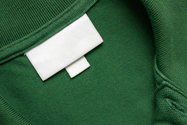 istock Blank white laundry care clothes label on green shirt fabric texture background 2215131532