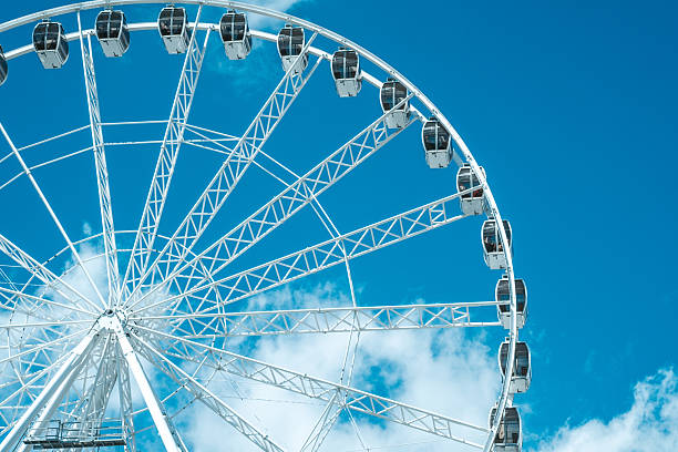 istock A towering ferris wheel stands against a blue sky with fluffy clouds during a bright afternoon 2215131974