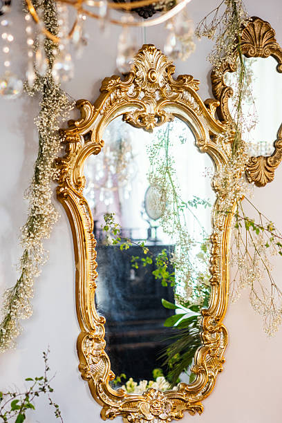 istock Elegant vintage mirror surrounded by delicate flowers in bright setting 2215141958