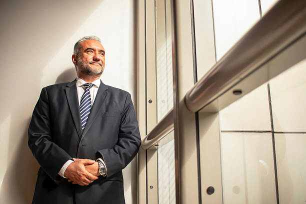 istock Pensive businessman looking out the window in modern office building 2215144385