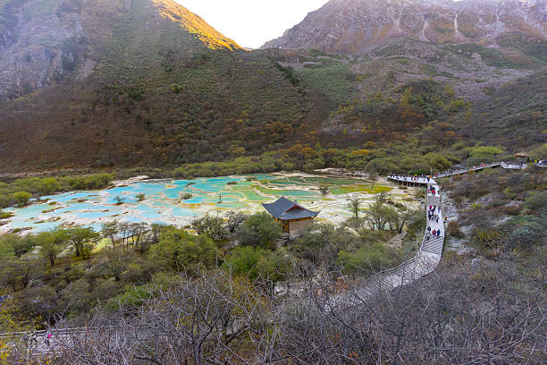 Huanglong, Sichuan, China - Oct 14,2024 : Unidentified people visit Multi-Colored Pool in Huanglong National Park, famous for its colorful pools formed by calcite deposits in Sichuan, China on Oct 14,2024.