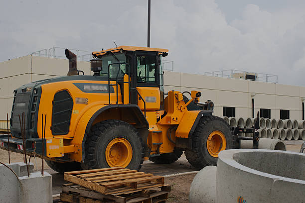 istock Yellow Construction Loader Parked at Industrial Site with Building and Materials. 2215149075