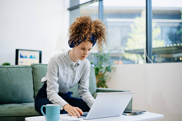 istock woman working on laptop from couch, in a calm and modern remote office setup, symbolizing freelance, tech, and independent lifestyle 2215153764
