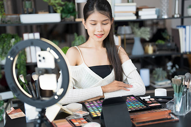 istock Asia woman beauty influencer makeup artist vlogger live streaming makeup tutorial on smartphone for social media 2215154564