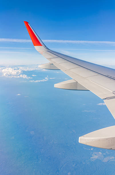 istock View from the airplane window at a beautiful cloudy sky and the airplane wing 2215155276