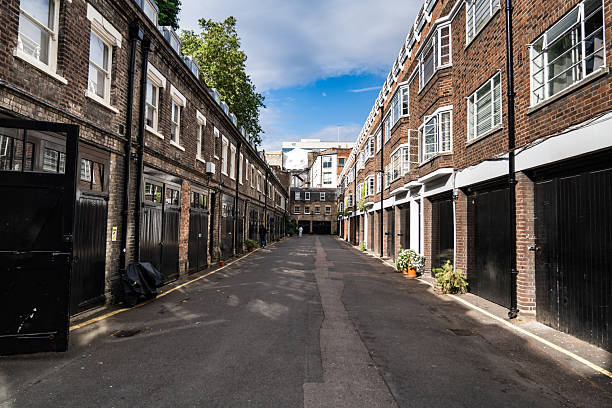 istock Narrow Alley Between Classic Brick Buildings Under Clear Sky, Featuring Historic Architecture and Small Residential Windows in a Peaceful Urban Setting. 2215156346