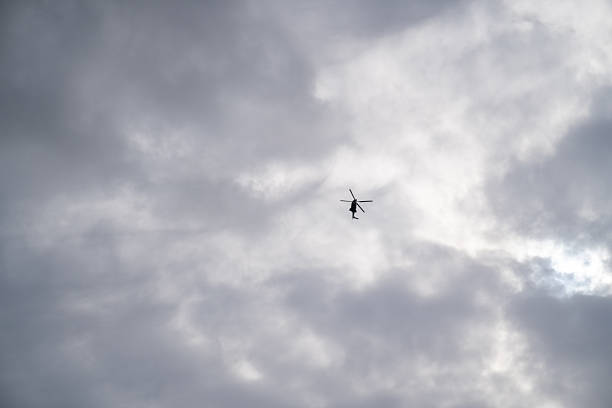 One helicopter, no others. Sky above hangs thick and quiet. Lines remain simple. Darkness within motion suggests distance, intention, or watchfulness beneath the grey.