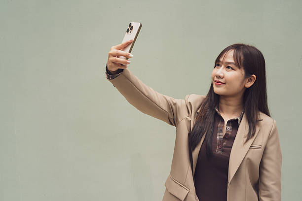 istock young woman with mobile phone taking selfie 2215163792
