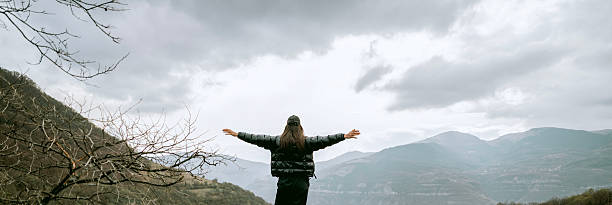 istock Woman standing in the mountain with open arms 2215164071