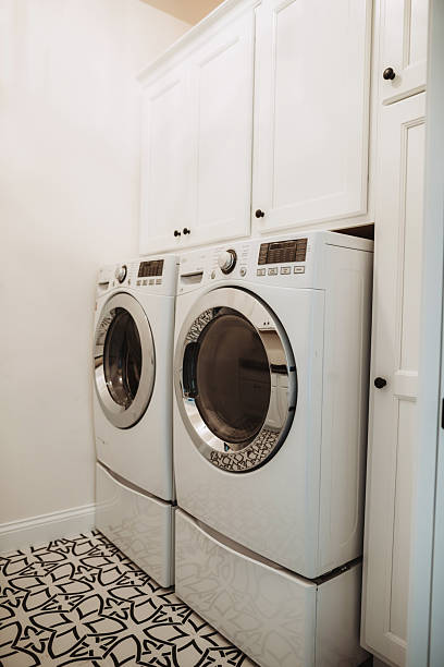 istock Laundry room with upright washer and dryer for clothes 2215164524