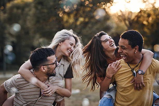 istock Cheerful couples having fun while piggybacking in the park. 2215166869