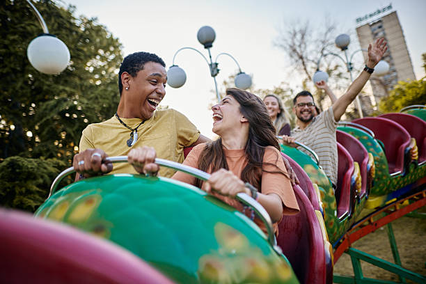 istock Cheerful diverse couple having fun while riding on rollercoaster at amusement park. 2215167431