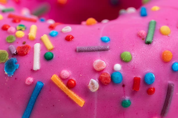 istock Pink glazed donut with colorful sprinkles. Closeup. 2215167480