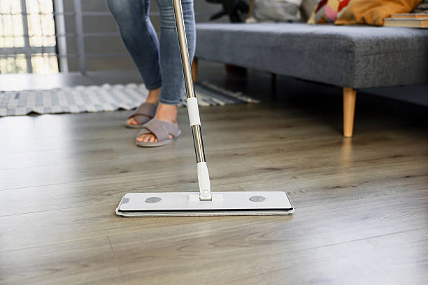 istock Woman mopping, wiping floor in modern home setting 2215167572