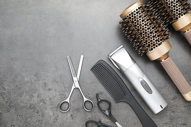 istock Professional hair clipper, different combs and scissors on grey surface, flat lay 2215169866