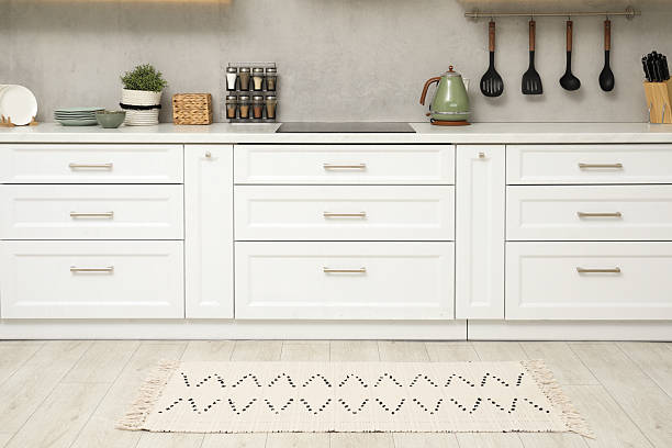 istock Stylish soft rug on wooden floor in kitchen 2215169918