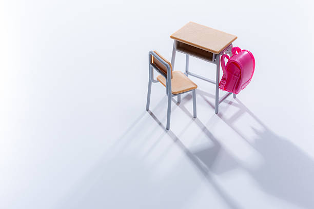 toy small school desk and chair against yellow background