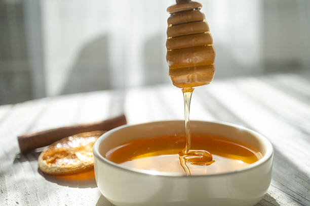 istock honey dripping from a wooden spoon 2215173236