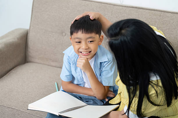 istock Back to School. Child smiling while studying with mother at home. 2215175209