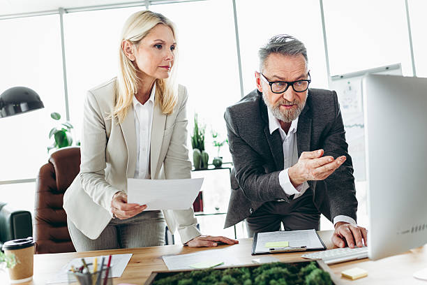istock Business professionals collaborating in a modern office with documents and computer for effective team discussion and decision making 2215175650