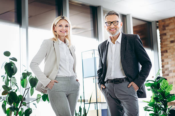 istock Senior business professionals collaborating in a bright office environment with modern workplace design and green plants. 2215175667