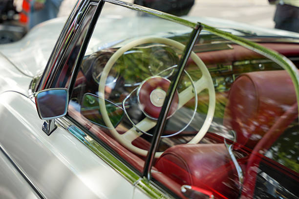 Germany Berlin May 11, 2025. Mercedes interior through window. View through the window of the steering wheel and red leather seats of a classic Mercedes. Elegance and craftsmanship are reflected in every detail.