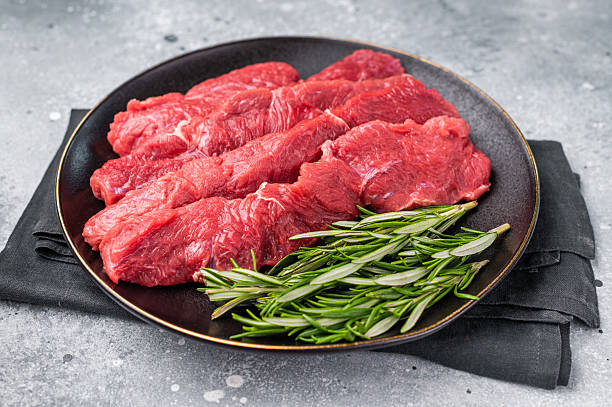 istock Raw bison meat presented with fresh herbs and spices, inspiring bold flavors and unique recipes for adventurous food lovers. grey background. top view 2215178710