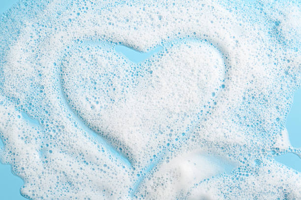 istock Heart shape made of detergent foam on light blue background, top view 2215179930