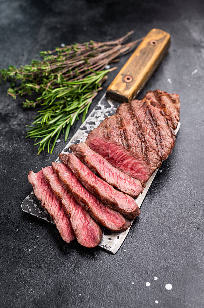 istock Savory shoulder steak Denver, beautifully cooked on the grill, highlighting its marbled texture and succulent taste. black background. top view 2215180334