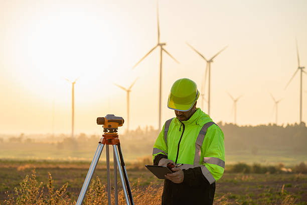 istock A field engineer surveys the land at sunset, with wind turbines behind as technology meets clean energy. 2215181089