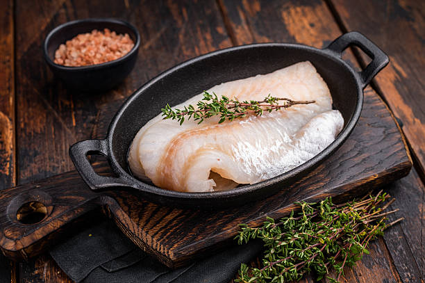 istock Pristine raw cod fillet, waiting to be marinated and cooked to perfection for a delightful dining experience. wooden background. top view 2215181193