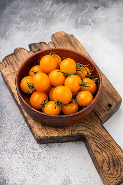 istock Fresh small yellow cherry tomatoes assortment, mini organic cocktail tomate mix. grey background. top view 2215181196