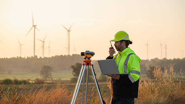 istock A field engineer surveys the land at sunset, with wind turbines behind as technology meets clean energy. 2215181206