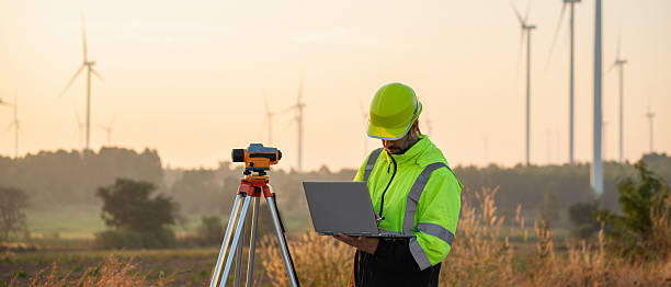 istock A field engineer surveys the land at sunset, with wind turbines behind as technology meets clean energy. 2215181227