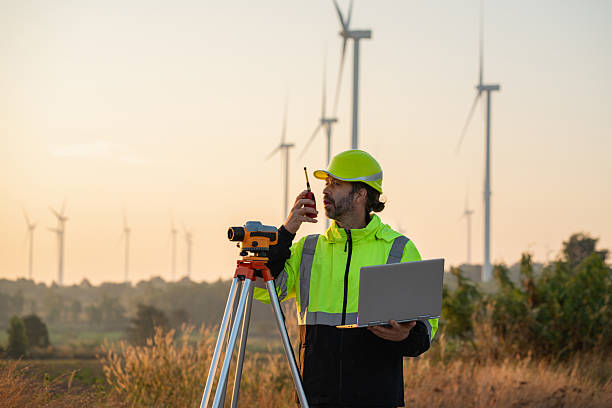 istock A field engineer surveys the land at sunset, with wind turbines behind as technology meets clean energy. 2215181245